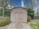 Outdoor storage shed with double doors surrounded by greenery and gravel at 9539 Errington Ln, Mint Hill, NC 28227