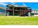 Spacious backyard view of a two-story home featuring multiple decks and stairs, perfect for outdoor entertaining at 9677 Garamont Nw Pkwy, Concord, NC 28027