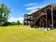 Two-story home with multi-level deck and stairs, with a large grassy yard at 9677 Garamont Nw Pkwy, Concord, NC 28027