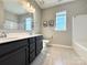 Bright bathroom featuring dual vanity, tiled floor and shower over bath at 9677 Garamont Nw Pkwy, Concord, NC 28027