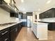 Beautiful kitchen featuring stainless steel appliances, dark cabinets, and center island with granite countertops at 9677 Garamont Nw Pkwy, Concord, NC 28027