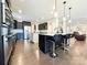 Open kitchen featuring granite countertops, stainless appliances, dark cabinets, and center island with bar seating at 9677 Garamont Nw Pkwy, Concord, NC 28027