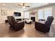 Comfortable living room with hardwood floors, fireplace, TV, and cozy reclining chairs at 9677 Garamont Nw Pkwy, Concord, NC 28027
