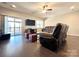 Living room with hardwood floors, ceiling fan, modern tv, and slider to the outside at 9677 Garamont Nw Pkwy, Concord, NC 28027