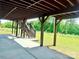 A spacious outdoor area featuring support columns and stairs leading to a deck, with a lawn and trees beyond at 9677 Garamont Nw Pkwy, Concord, NC 28027