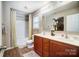 Well-lit bathroom featuring a double sink vanity, shower-tub, and a window for natural light at 9704 Cayenne Dr, Charlotte, NC 28214