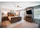 Spacious main bedroom featuring a ceiling fan, large windows, and stylish wood furniture at 9704 Cayenne Dr, Charlotte, NC 28214