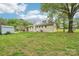 Expansive backyard with lush green grass, mature trees, and a charming shed for storage or hobbies at 9907 Hagers Rd, Huntersville, NC 28078