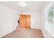 Bright bedroom with hardwood floors, white walls, and closet with wooden sliding doors at 9907 Hagers Rd, Huntersville, NC 28078