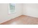 Cozy bedroom with wood-look floors, white walls, and a window with bright natural light at 9907 Hagers Rd, Huntersville, NC 28078