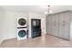 Functional flex space featuring modern washer and dryer, built-in cabinets, and wood-look flooring for versatile use at 9907 Hagers Rd, Huntersville, NC 28078