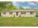 Inviting one-story home with a classic facade, complemented by a lush green lawn and neatly trimmed shrubs at 9907 Hagers Rd, Huntersville, NC 28078
