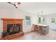 Open-concept living space featuring a brick fireplace, breakfast bar, and ample natural light, creating a cozy atmosphere at 9907 Hagers Rd, Huntersville, NC 28078