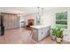 Open-concept living area with a brick fireplace, gray built-in cabinets, and natural light streaming through the window at 9907 Hagers Rd, Huntersville, NC 28078
