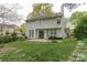 Back of house features a well-maintained lawn, a patio for outdoor seating and entertainment, and lush landscaping at 108 Kinderston Dr, Davidson, NC 28036
