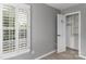 Neutral bedroom with gray walls, a window with white shutters, and a closet with an open door at 108 Kinderston Dr, Davidson, NC 28036