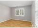 Bright bedroom featuring wood laminate flooring, neutral walls, and a window fitted with white shutters at 108 Kinderston Dr, Davidson, NC 28036