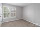 Bright bedroom featuring carpet flooring and a window fitted with white shutters at 108 Kinderston Dr, Davidson, NC 28036