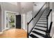 Welcoming foyer with hardwood floors, black and white staircase, and a view to the front door at 108 Kinderston Dr, Davidson, NC 28036
