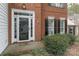 Close up of a home's front door showing the sidelights, brick facade, and manicured landscaping at 108 Kinderston Dr, Davidson, NC 28036
