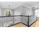 Second floor landing with chandelier and black and white handrail at 108 Kinderston Dr, Davidson, NC 28036