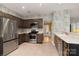 Traditional kitchen featuring stainless steel appliances, dark wood cabinets, and patterned wallpaper at 108 Kinderston Dr, Davidson, NC 28036