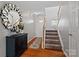 Welcoming foyer featuring wood floors, a decorative mirror and carpeted staircase at 10920 Walking Path Ln, Charlotte, NC 28213