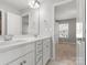 Bathroom featuring a double vanity with white cabinets, a mirror and a doorway that leads to a bedroom at 110 Lantern Acres Dr, Mooresville, NC 28115