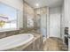 Bathroom with a large soaking tub, separate shower, and tiled walls at 110 Lantern Acres Dr, Mooresville, NC 28115