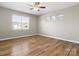 Bright bedroom with hardwood floors, a ceiling fan, and large windows overlooking the neighborhood at 110 Lantern Acres Dr, Mooresville, NC 28115
