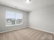 Well-lit bedroom with neutral carpet, a large window, and ample natural light at 110 Lantern Acres Dr, Mooresville, NC 28115
