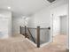 Bright hallway features wood and iron railing, carpeted floor, and entryways to other rooms at 110 Lantern Acres Dr, Mooresville, NC 28115