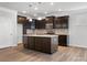Kitchen features a center island with stone countertop, dark cabinets, and modern appliances with recessed lights at 110 Lantern Acres Dr, Mooresville, NC 28115
