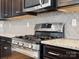 Modern kitchen featuring a stainless steel stove, gray backsplash, and granite countertops at 110 Lantern Acres Dr, Mooresville, NC 28115