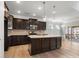 A modern kitchen boasts stainless steel appliances, dark cabinets and a center island with stone countertop at 110 Lantern Acres Dr, Mooresville, NC 28115
