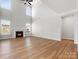 Open-concept living room with vaulted ceilings, fireplace, large windows for natural light, and wood floors at 110 Lantern Acres Dr, Mooresville, NC 28115