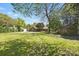 Spacious backyard with a lush lawn, mature trees, a storage shed, and a detached garage at 110 Tanglewood Dr, Kannapolis, NC 28081