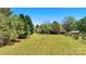 Lush backyard with a fire pit, mature trees, and a gentle slope, creating a serene outdoor space at 110 Tanglewood Dr, Kannapolis, NC 28081