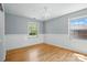 Sunlit bedroom featuring hardwood floors and paneled walls at 110 Tanglewood Dr, Kannapolis, NC 28081