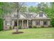 Charming brick home featuring a covered porch, manicured lawn, and mature trees enhancing curb appeal at 112 Spring Branch Rd, Fort Mill, SC 29715