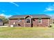 Back exterior view of brick home with manicured lawn and bay window at 115 Green Sw St, Concord, NC 28027
