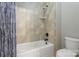 Bright bathroom with a shower-tub combo and neutral-colored tile at 116 Whispering Cove Ct, Mooresville, NC 28117