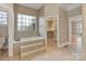 This large bathroom has a tub, a window, and an entrance to the walk-in closet at 116 Whispering Cove Ct, Mooresville, NC 28117