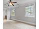A carpeted bedroom with neutral color scheme, ceiling fan, and large windows for natural light at 116 Whispering Cove Ct, Mooresville, NC 28117