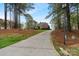 Long driveway leading up to an impressive home surrounded by tall trees at 116 Whispering Cove Ct, Mooresville, NC 28117