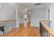 A view of the hardwood hallway with decorative molding and a wrought iron railing at 116 Whispering Cove Ct, Mooresville, NC 28117