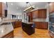 Open kitchen with stainless steel appliances, wood cabinets, hardwood flooring, and stone countertops at 116 Whispering Cove Ct, Mooresville, NC 28117
