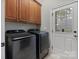 The laundry room features wooden cabinets and black appliances, creating a functional space at 116 Whispering Cove Ct, Mooresville, NC 28117