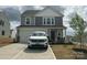 Charming two-story home featuring a gray exterior, two-car garage, and inviting front porch at 120 Parson Ln, Statesville, NC 28625