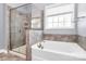 Well-lit bathroom with a glass-enclosed shower and a separate soaking tub, perfect for unwinding after a long day at 1224 Horsesugar Rd, Clover, SC 29710